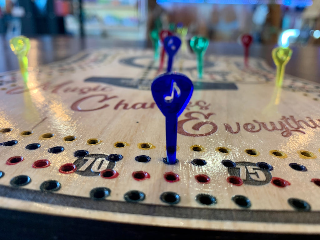 Close-up of a cribbage board with pegs.