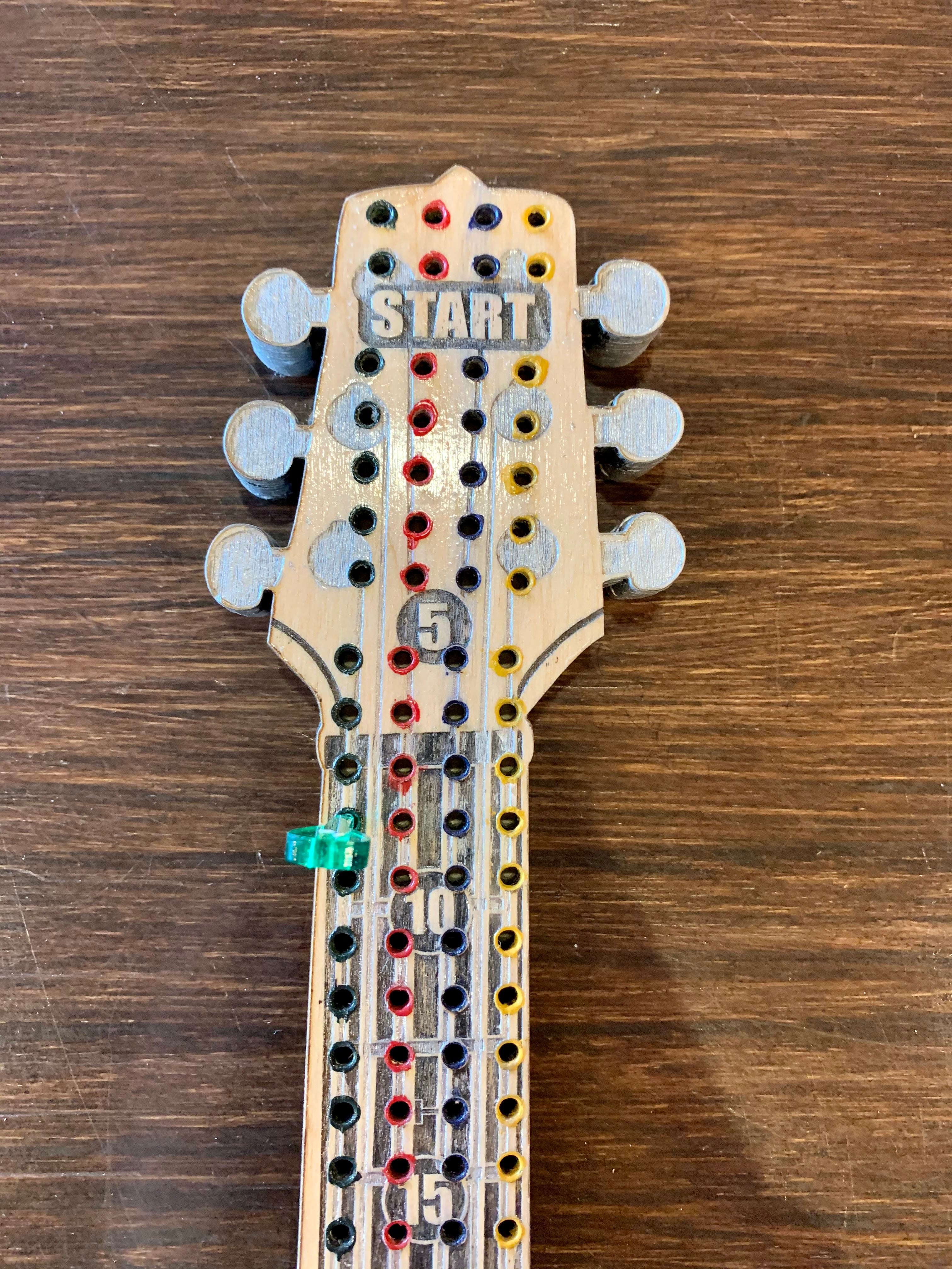 Wooden guitar-shaped cribbage board.