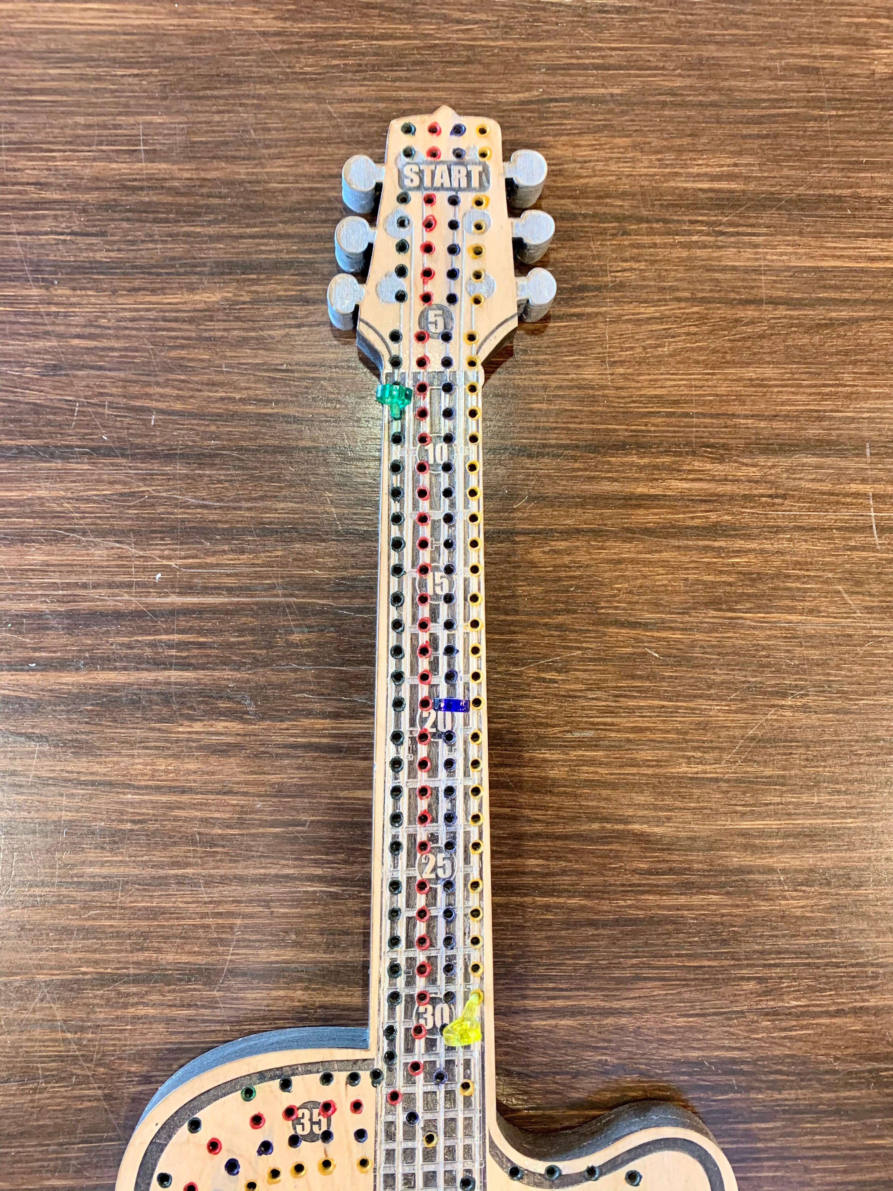 Wooden guitar-shaped cribbage board.