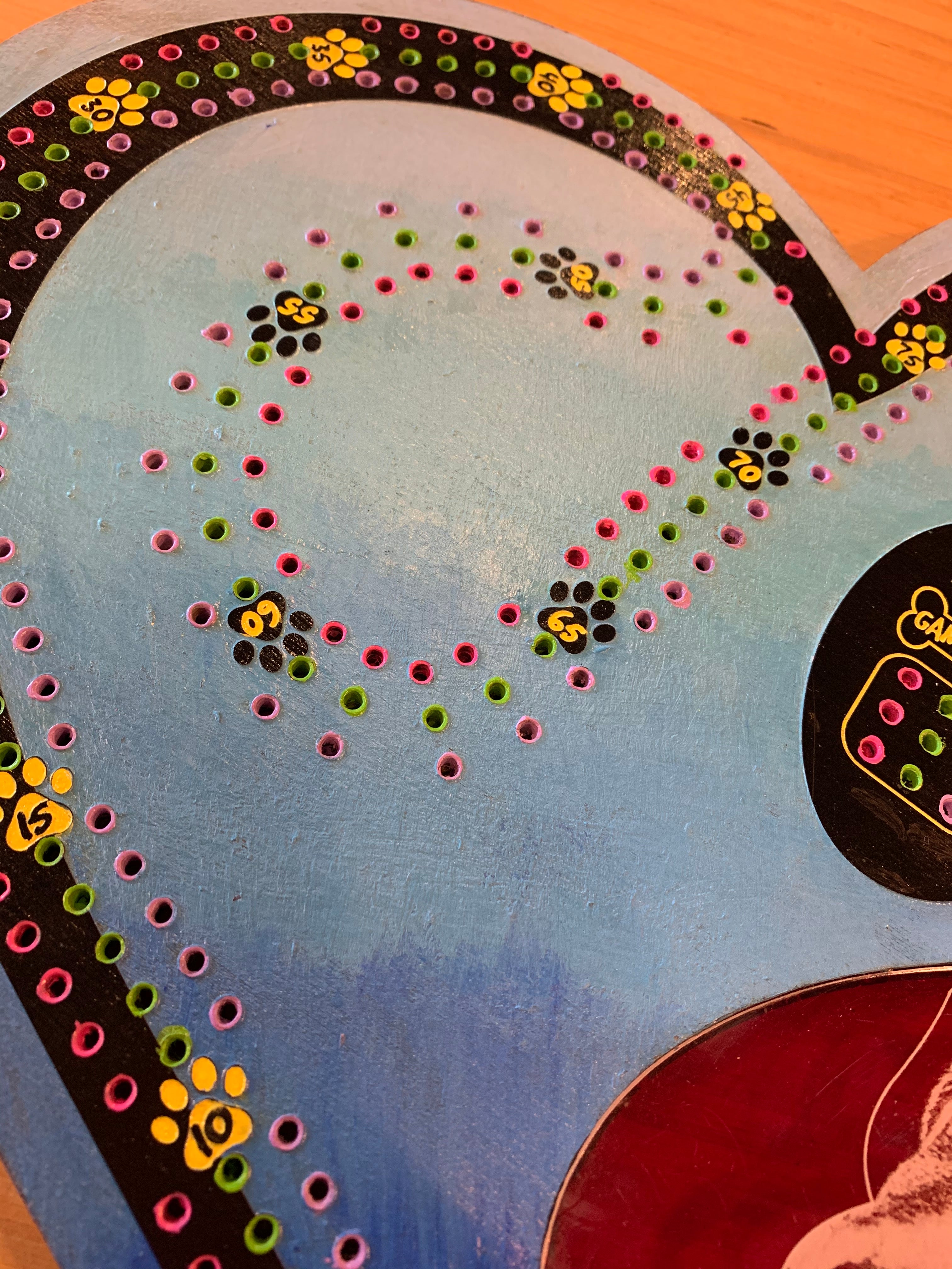 Decorative heart-shaped cribbage board with paw print design and dog engraving.