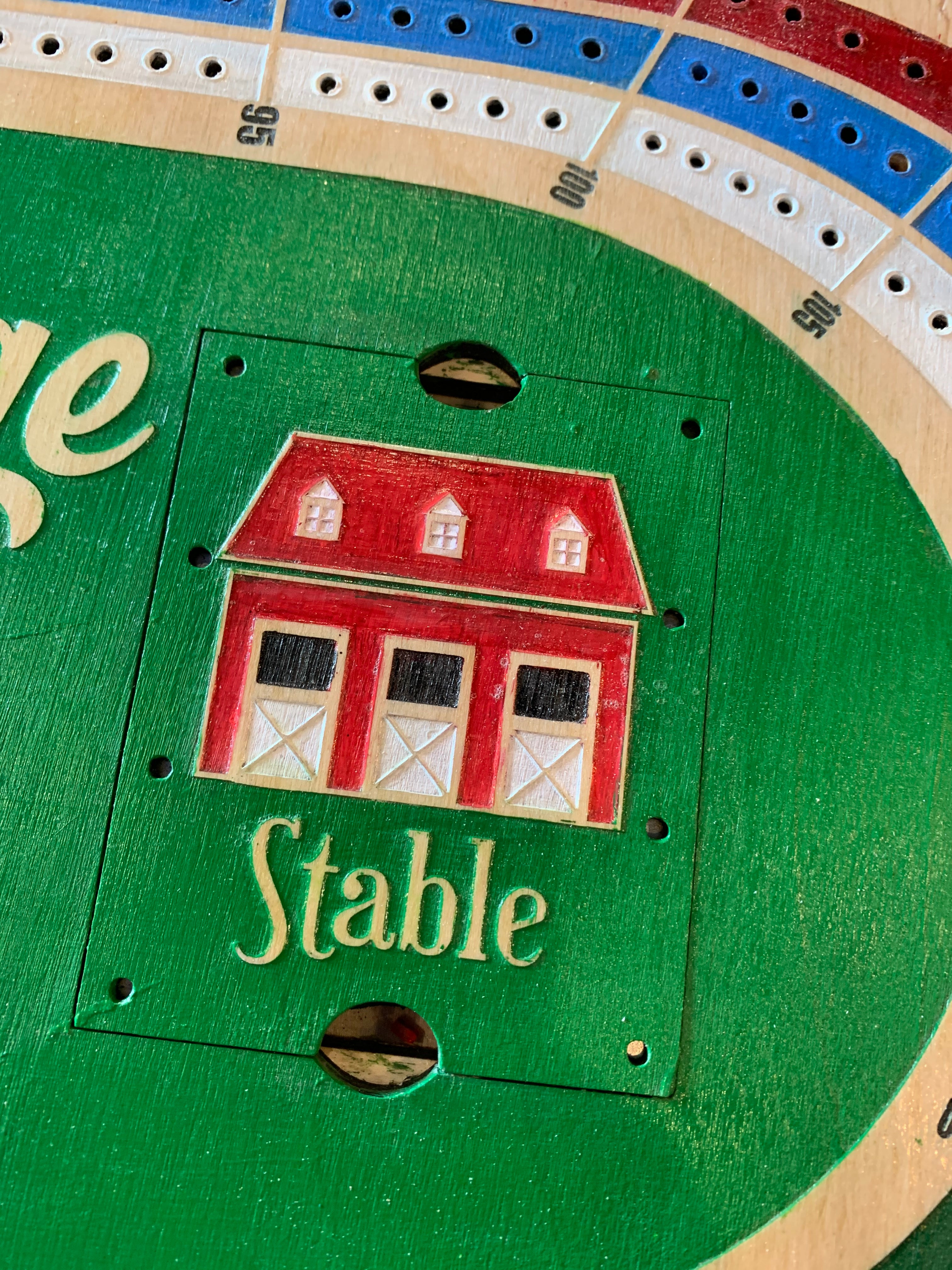 Close-up of a stable acrylic peg holder on a cribbage board.