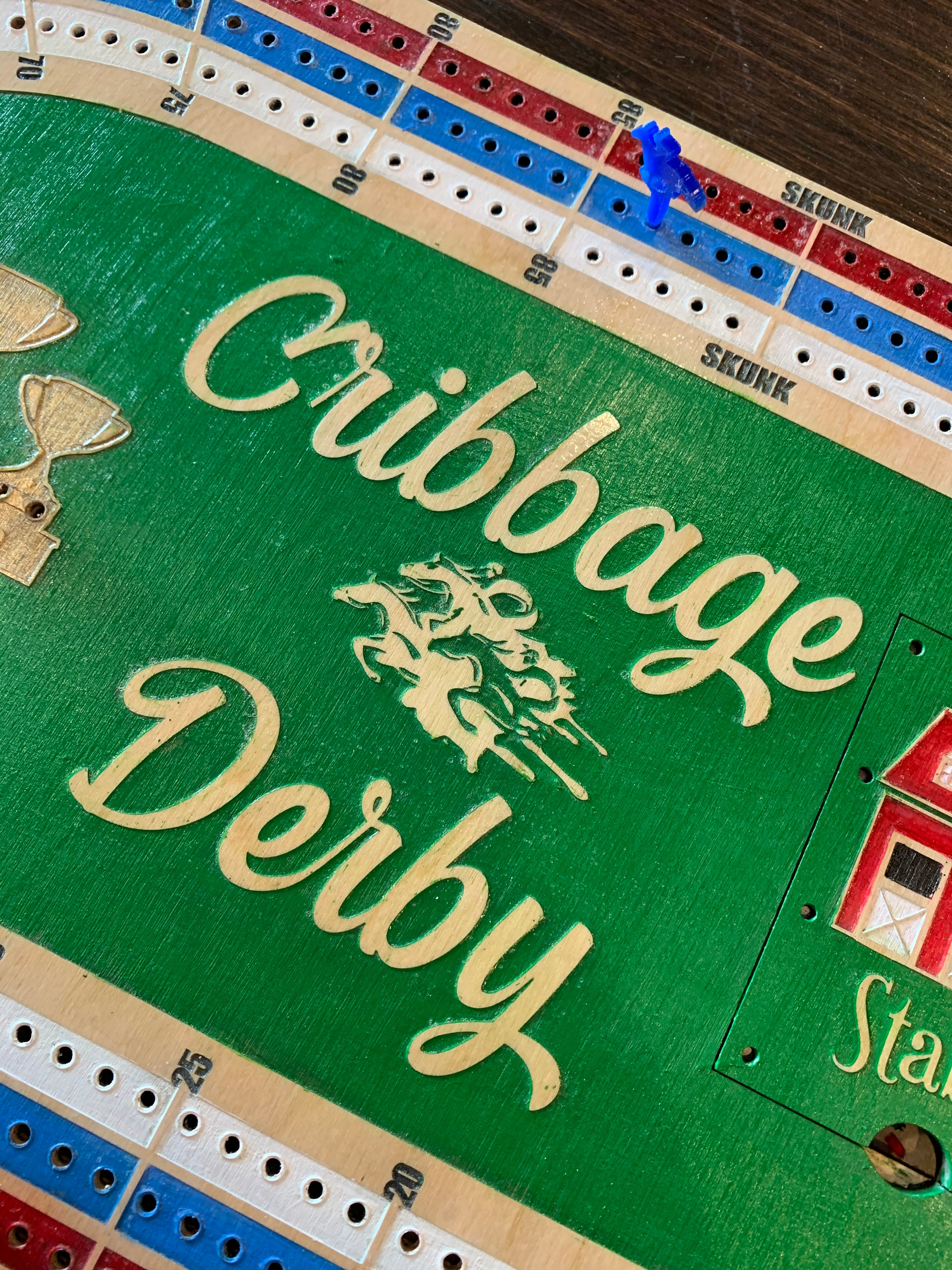 Cribbage Derby board game with green playing surface and acrylic pegs.