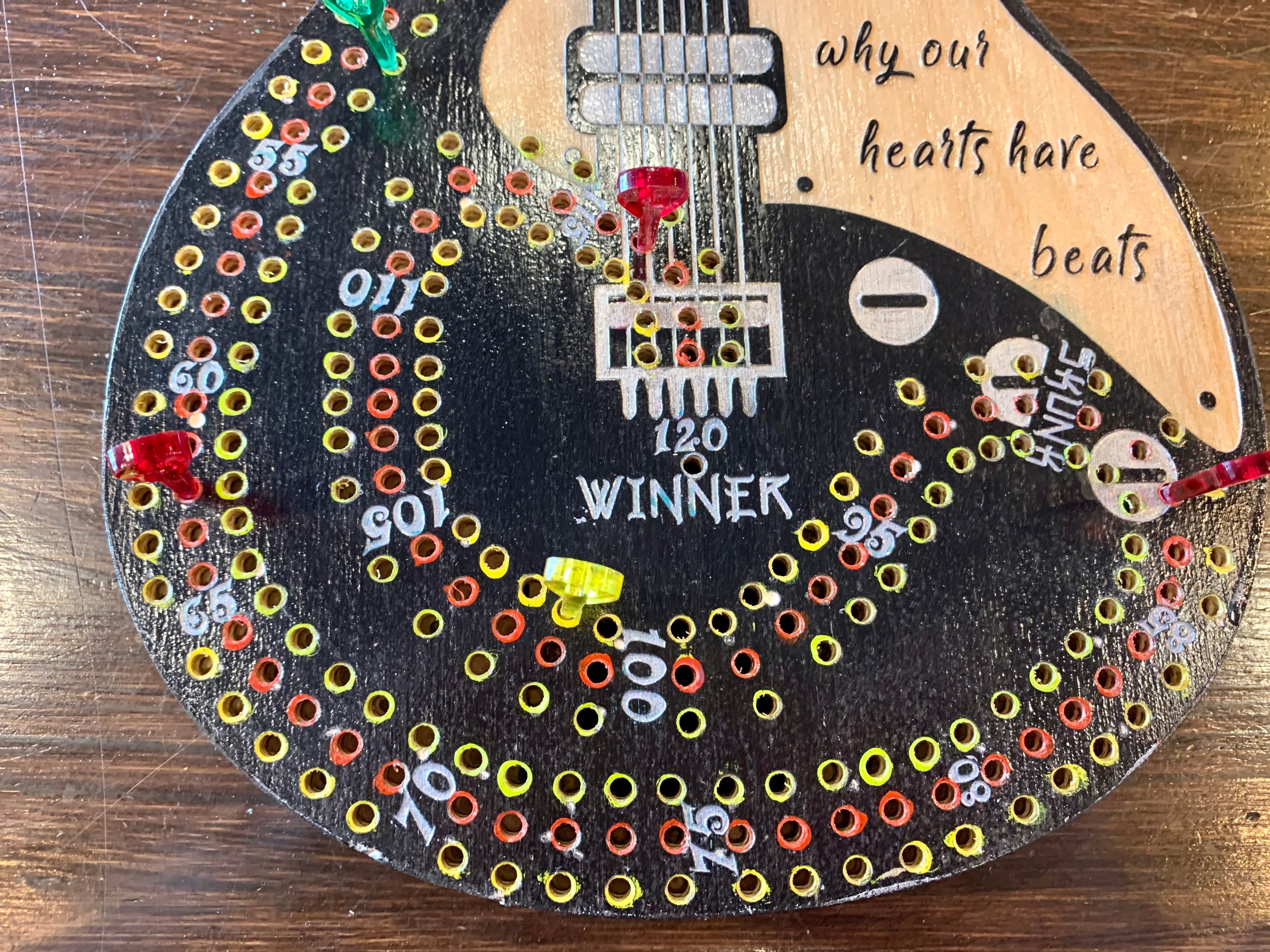Decorative guitar cribbage board hand painted on a wooden surface with custom cut acrylic pegs