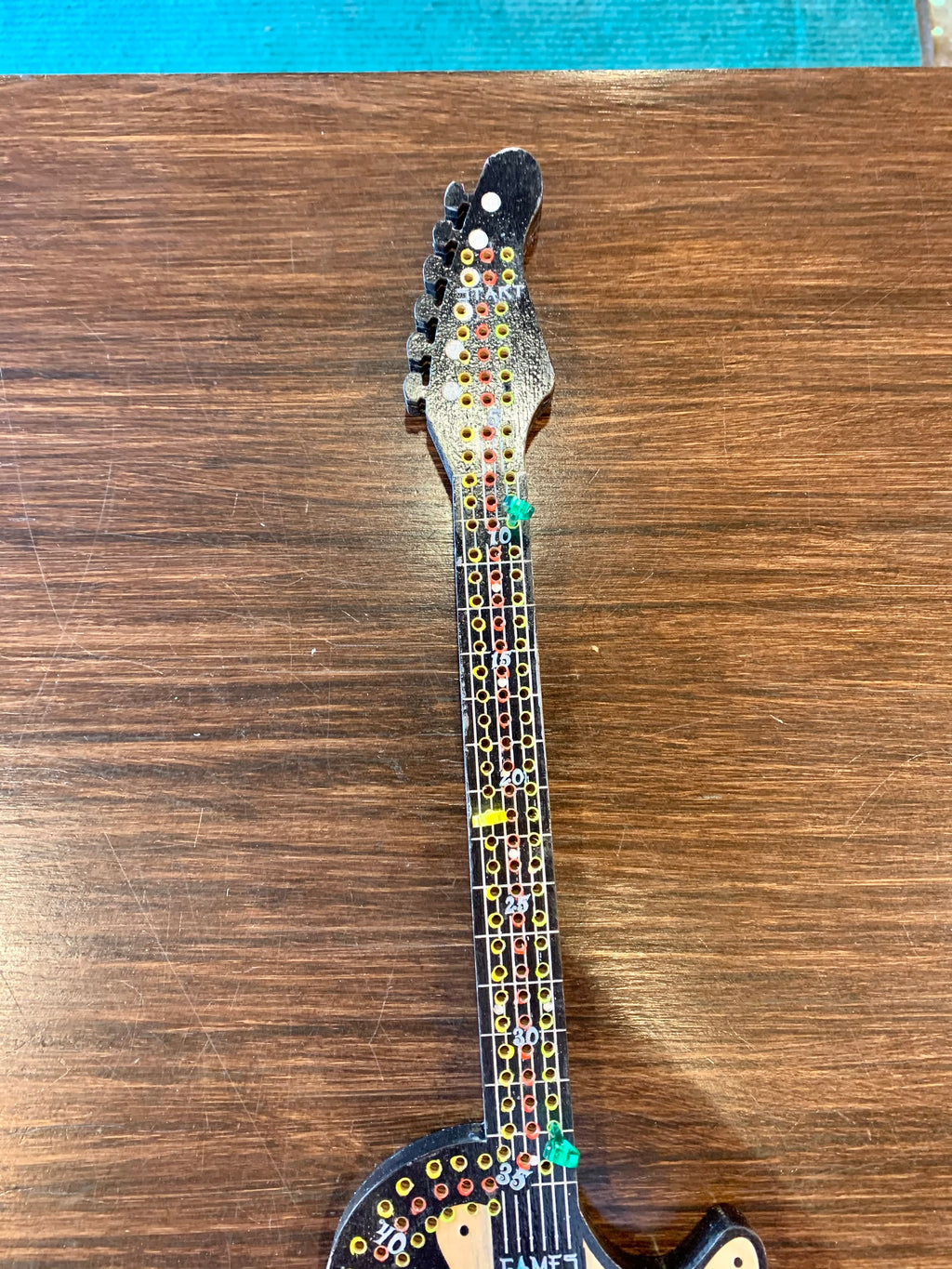 Decorative guitar cribbage board hand painted on a wooden surface