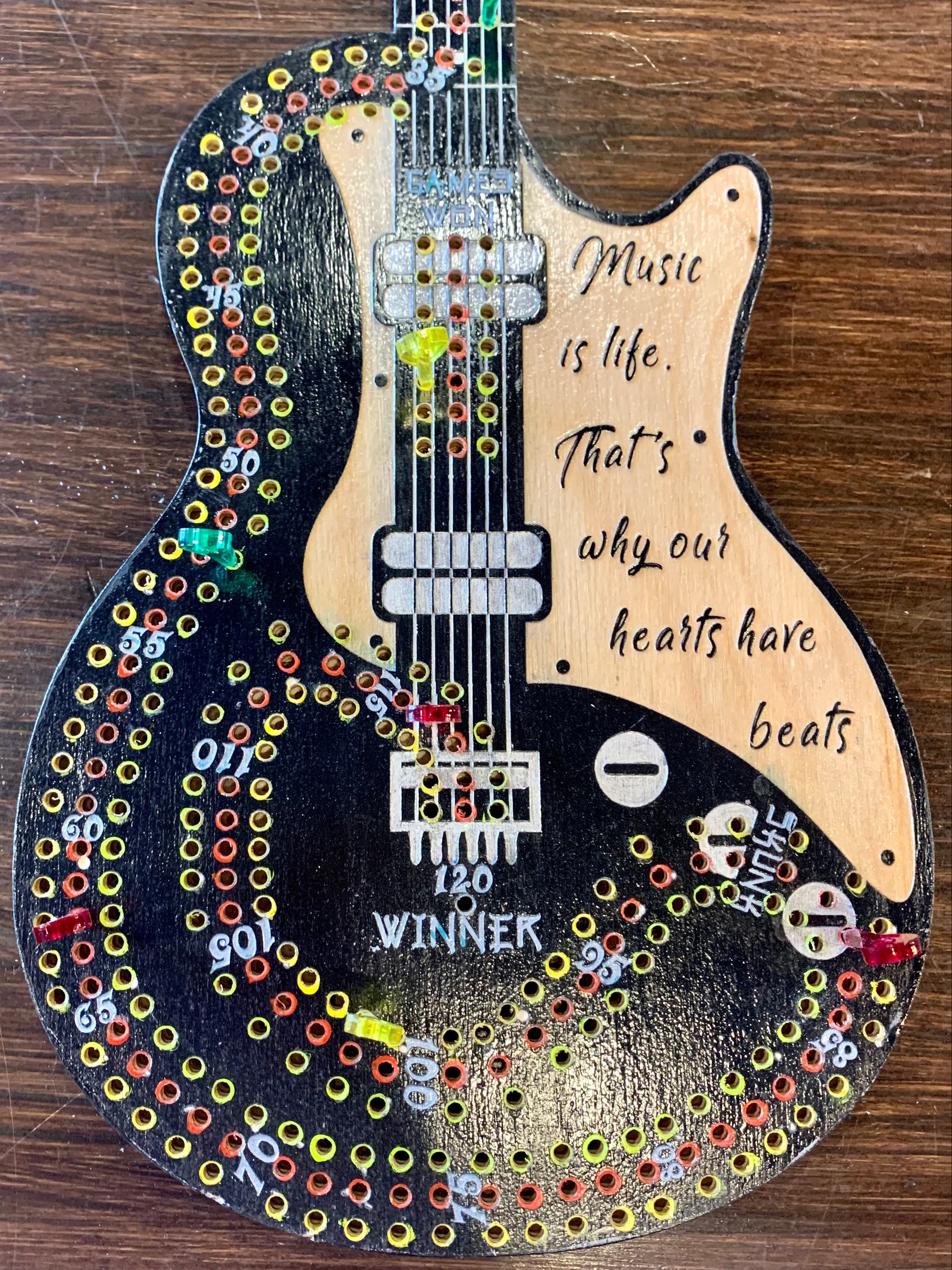 Decorative guitar cribbage board hand painted on a wooden surface