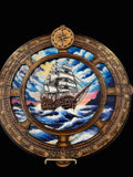 Decorative compass and ships wheel with ship illustration on a crib board