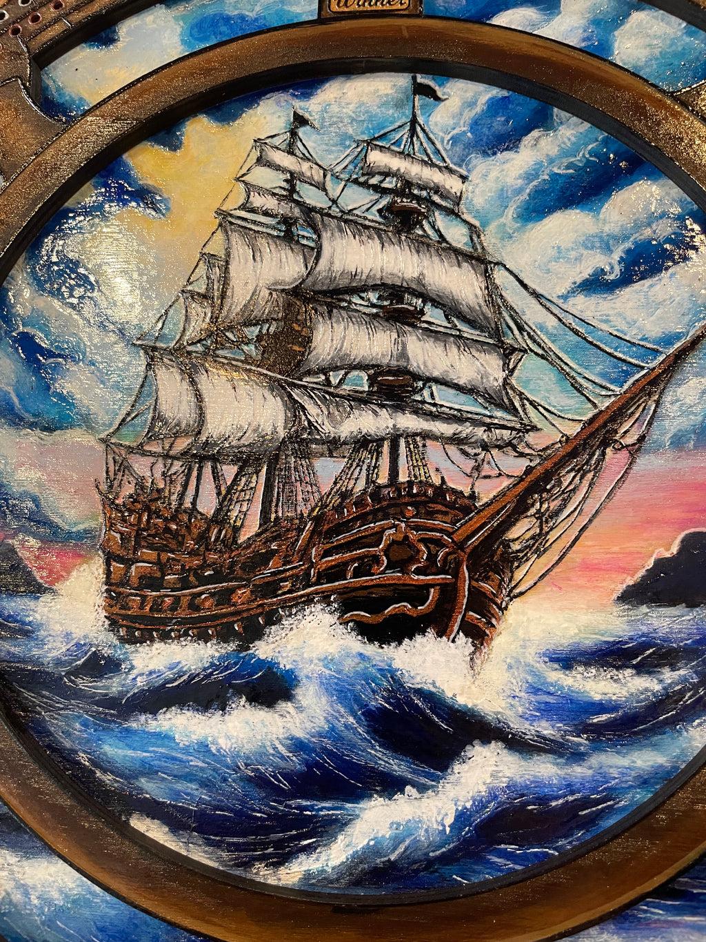 Decorative compass and ships wheel with ship illustration on a crib board