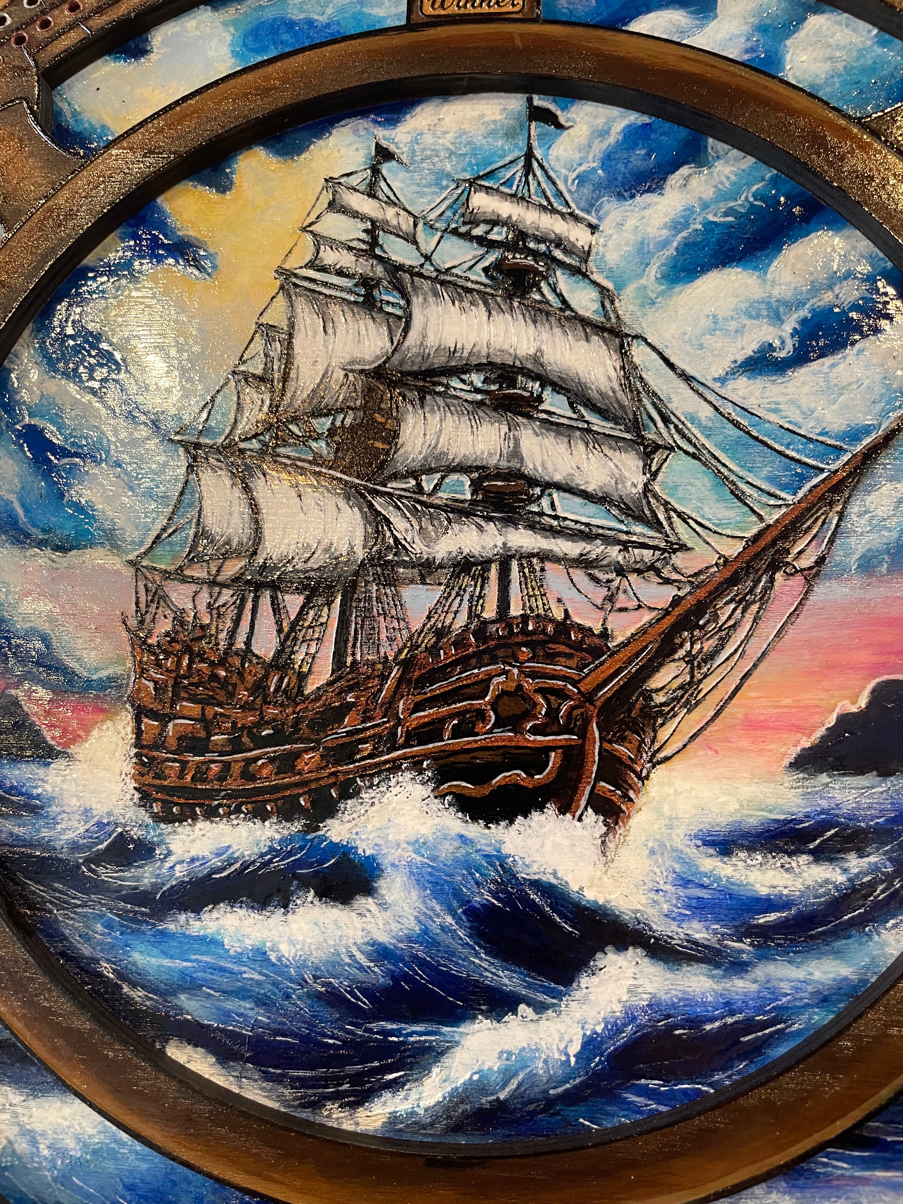 Decorative compass and ships wheel with ship illustration on a crib board