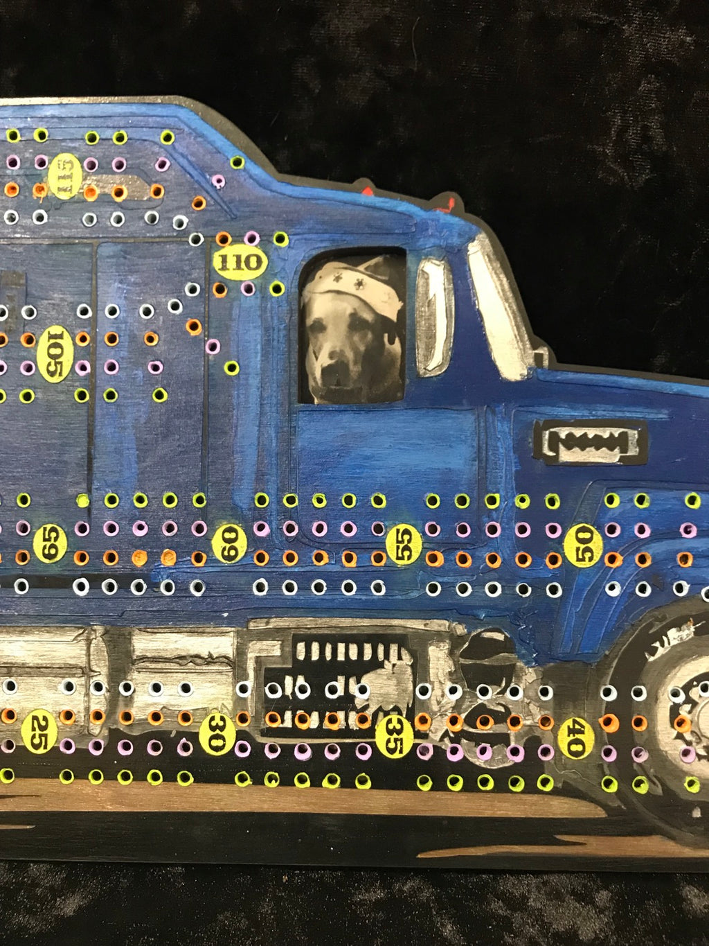 Cribbage board of a blue truck with a dog inside.