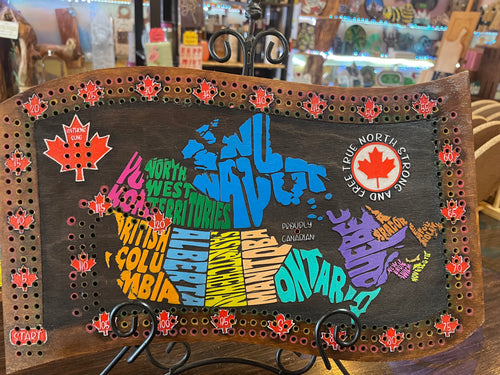 Map of Canada with colorful provinces on a wooden board with decorative elements.