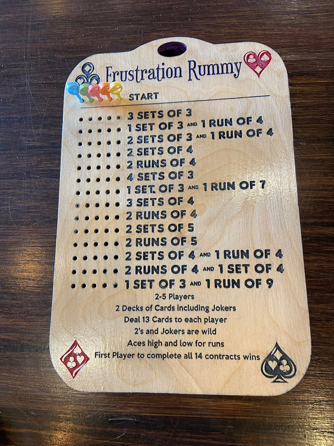 Wooden Frustration Rummy game board with rules on a wooden surface