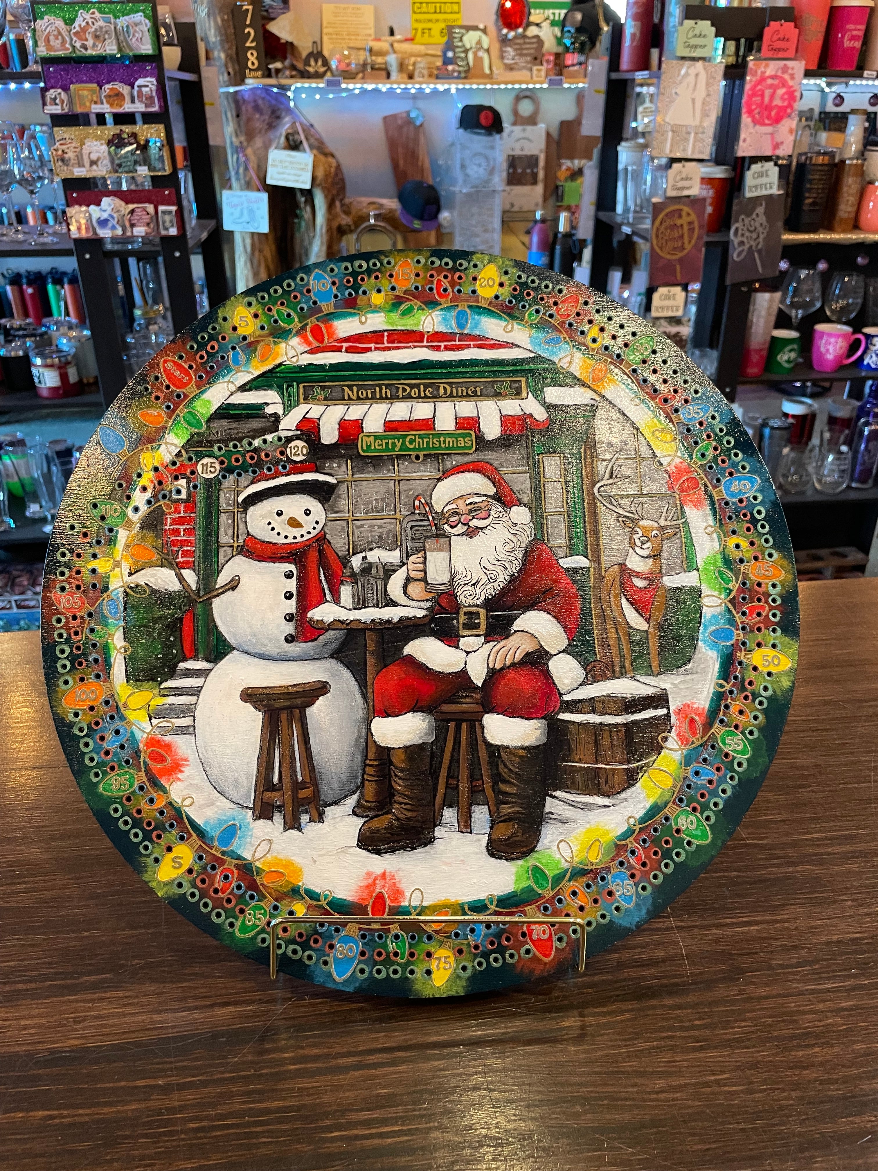 Decorative crib board with a festive design of Santa Claus and a snowman.