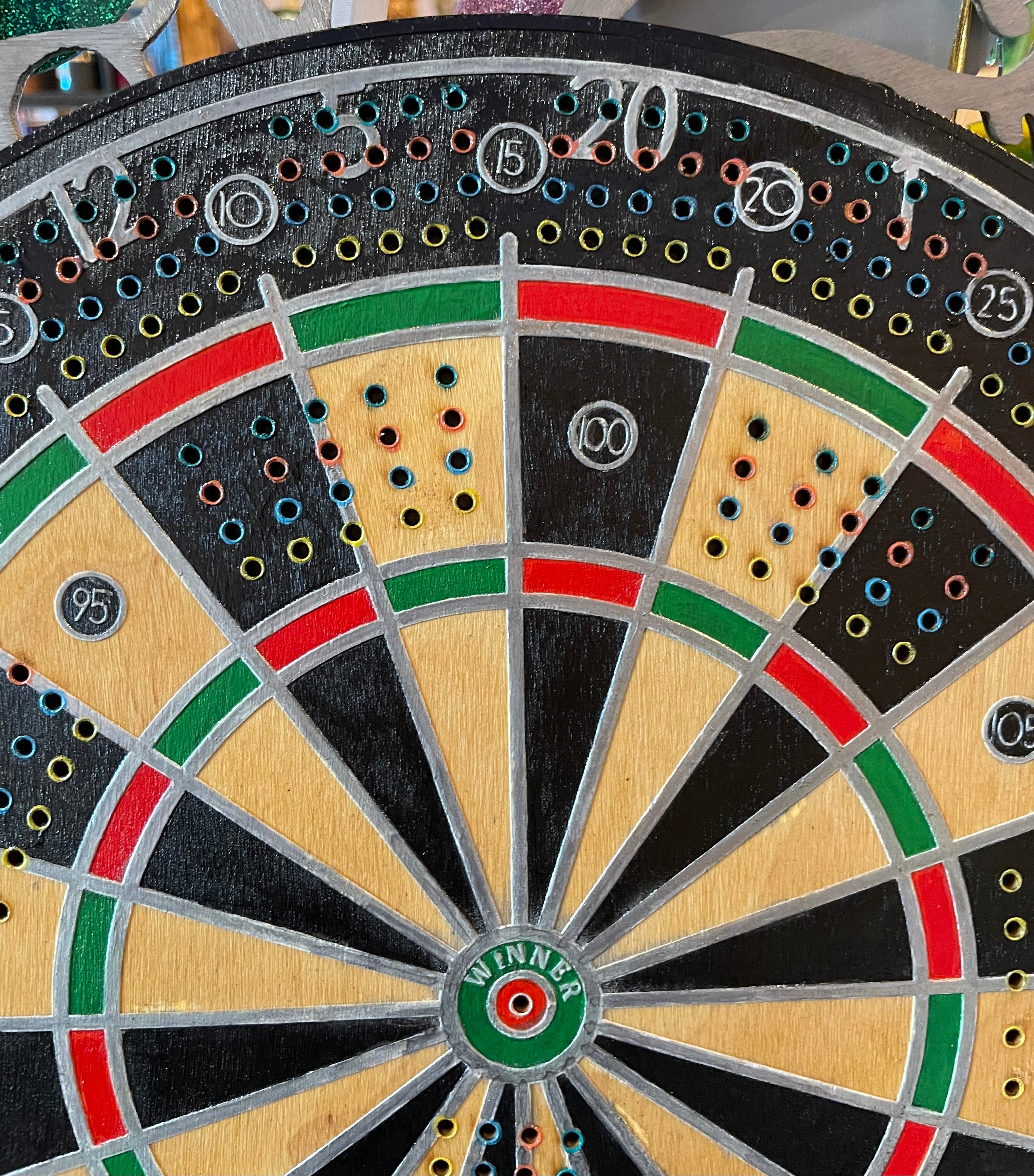 Close-up of a wooden dartboard with colorful scoring areas