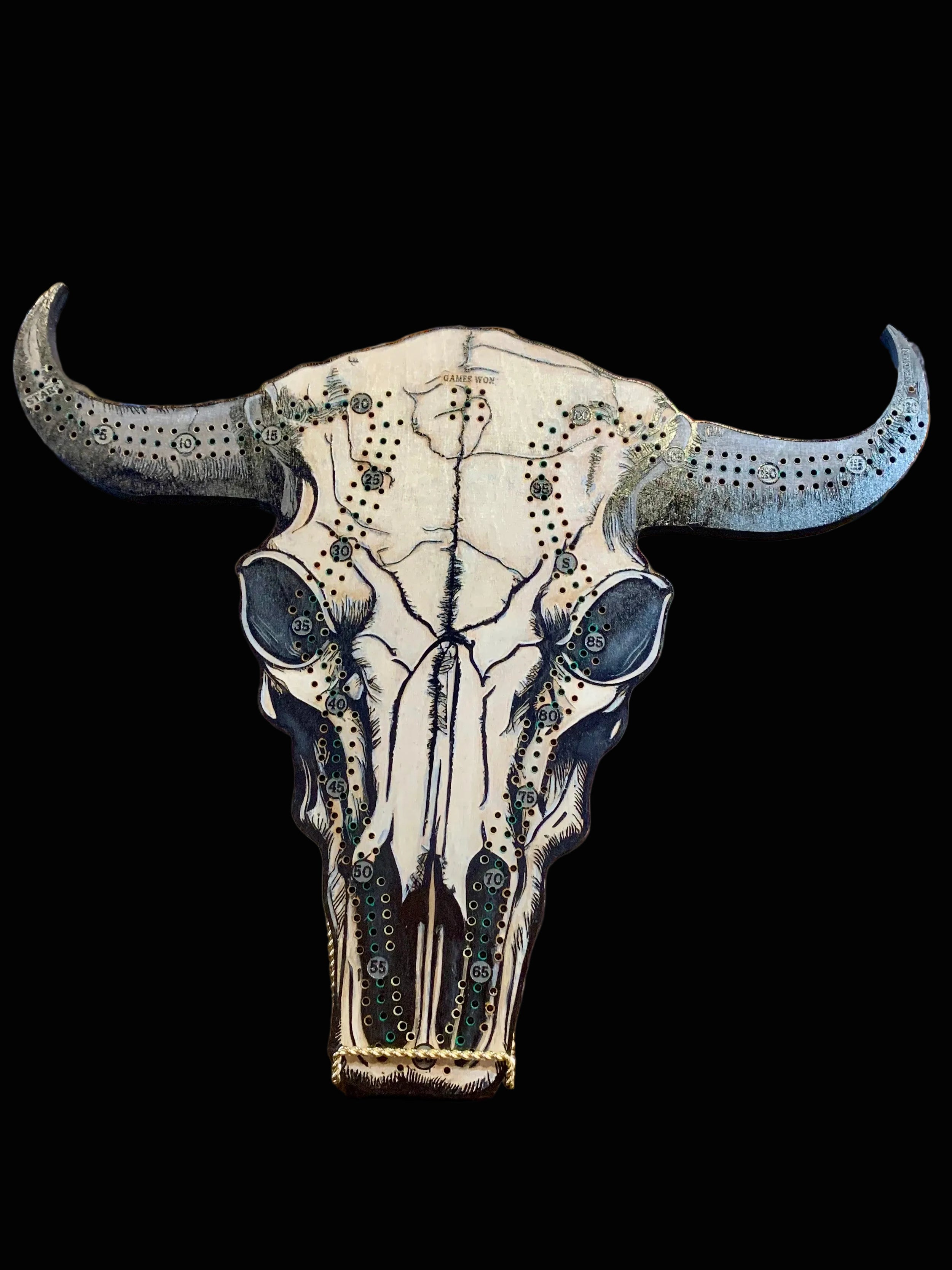 Decorative cow skull with artistic designs on a wooded crib board.