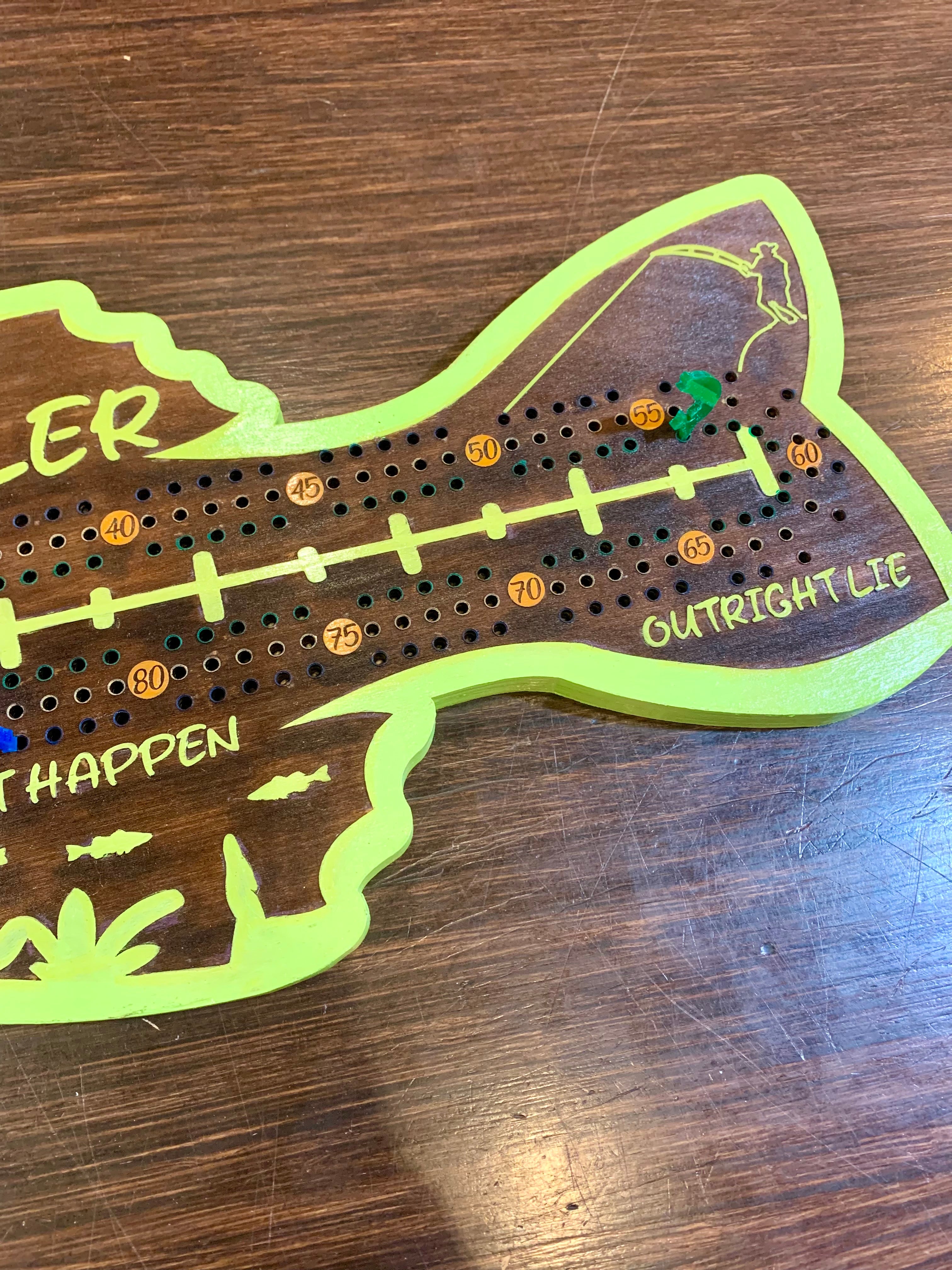 Wooden cribbage board with green border and text.