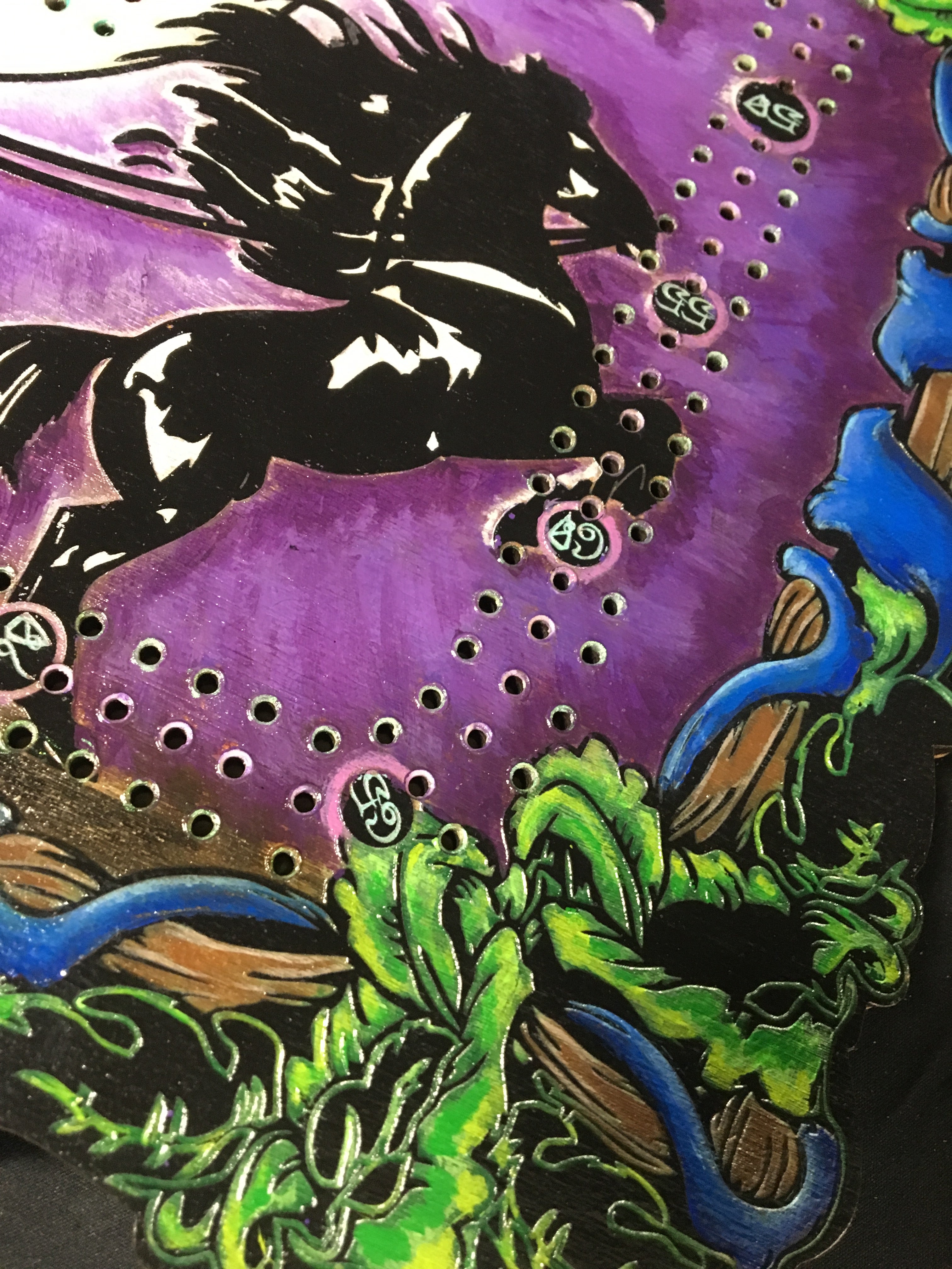 Colorful abstract design with black silhouette of a figure, green leaves, and purple background.