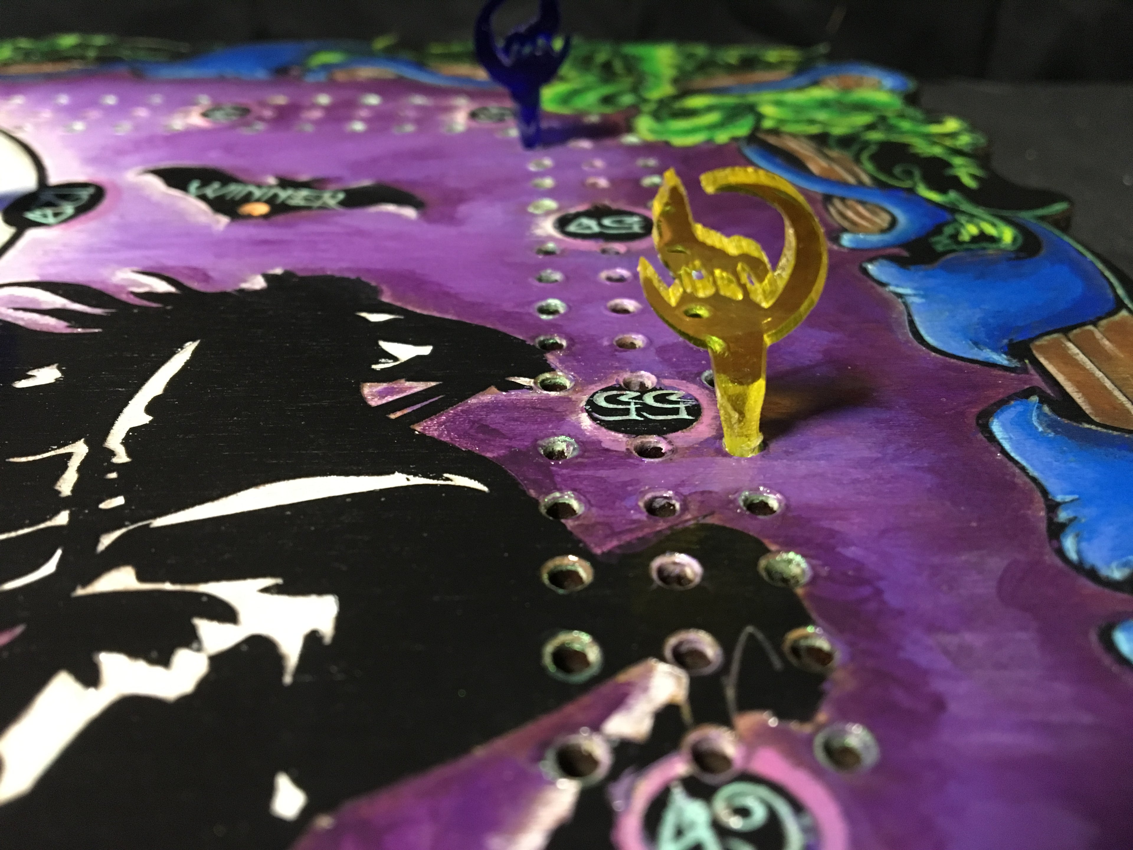 Colorful board game piece with a yellow and black design on a purple board