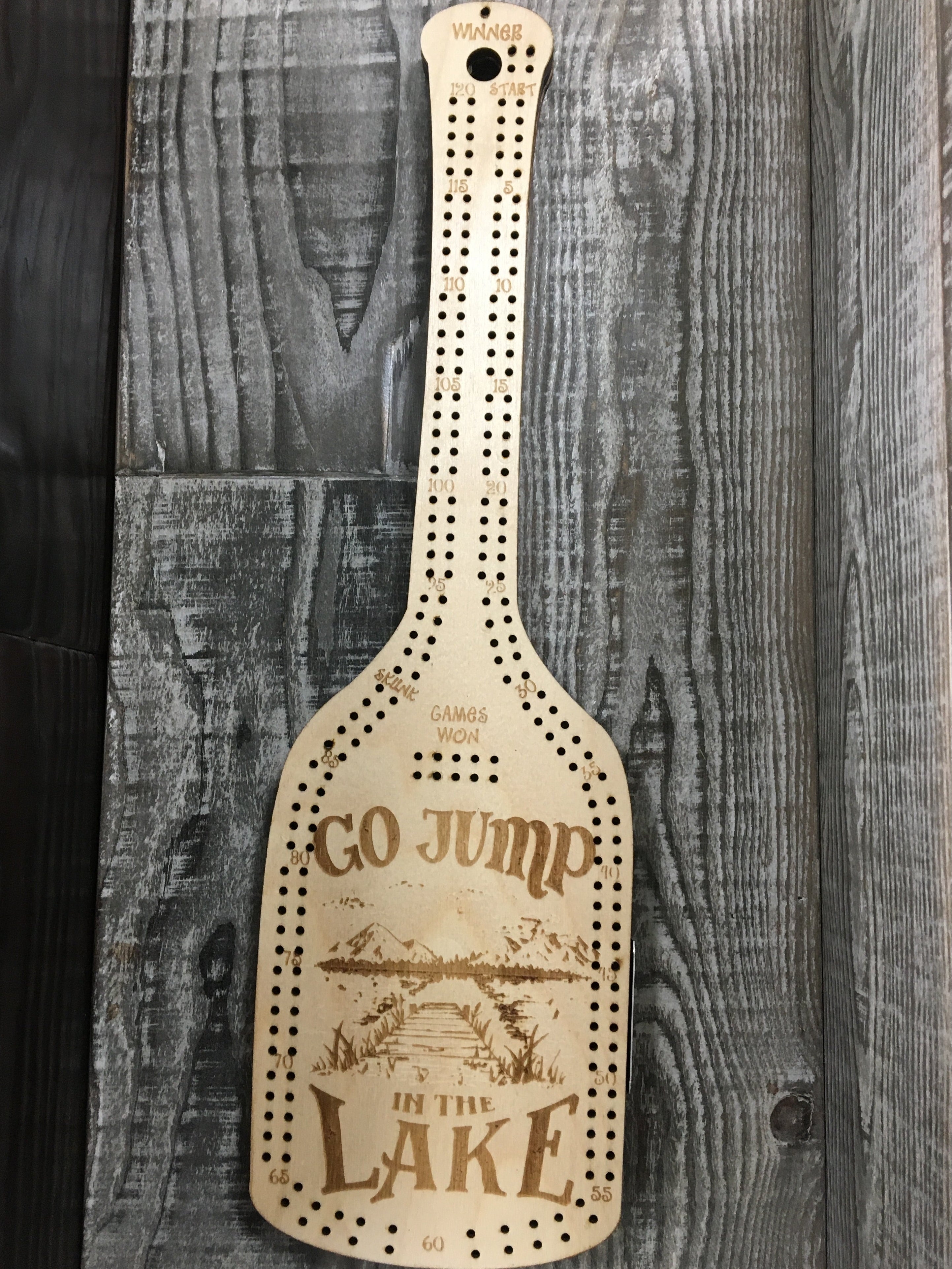 Wooden paddle cribbage board with "GO JUMP IN THE LAKE".
