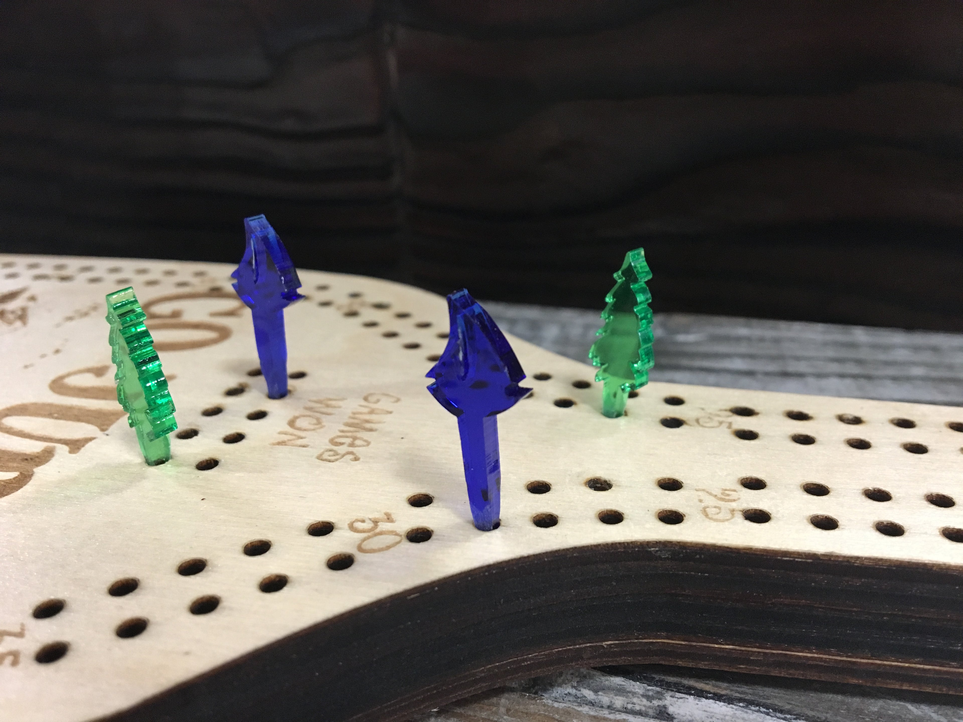 Colorful acrylic pegs on a cribbage board