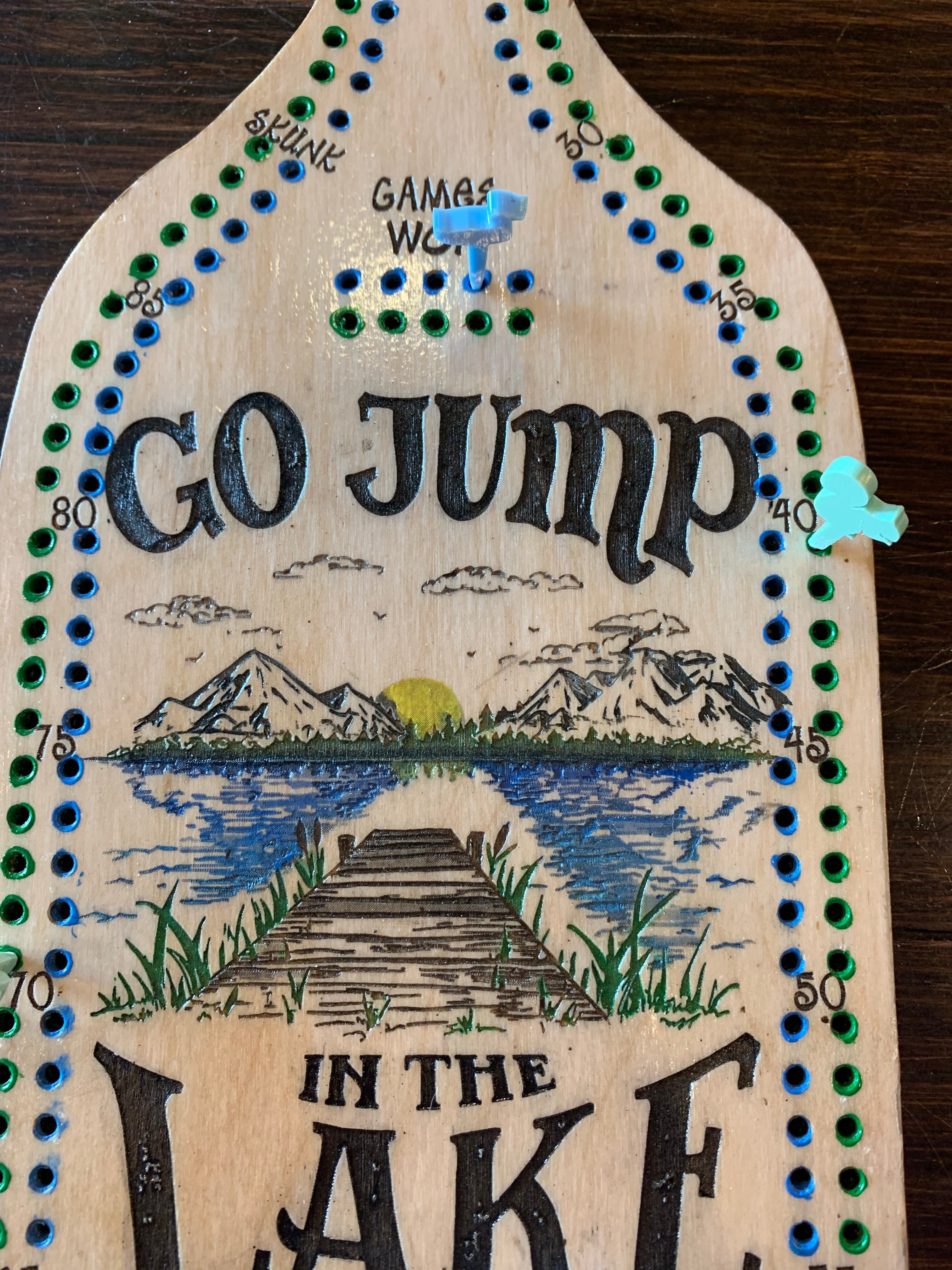 Wooden paddle crib board with artistic design.