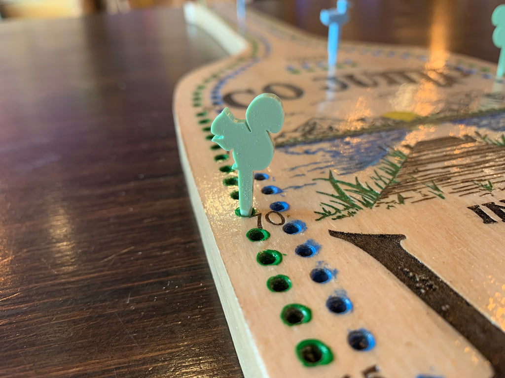 Close-up of a cribbage board game with acrylic pegs.