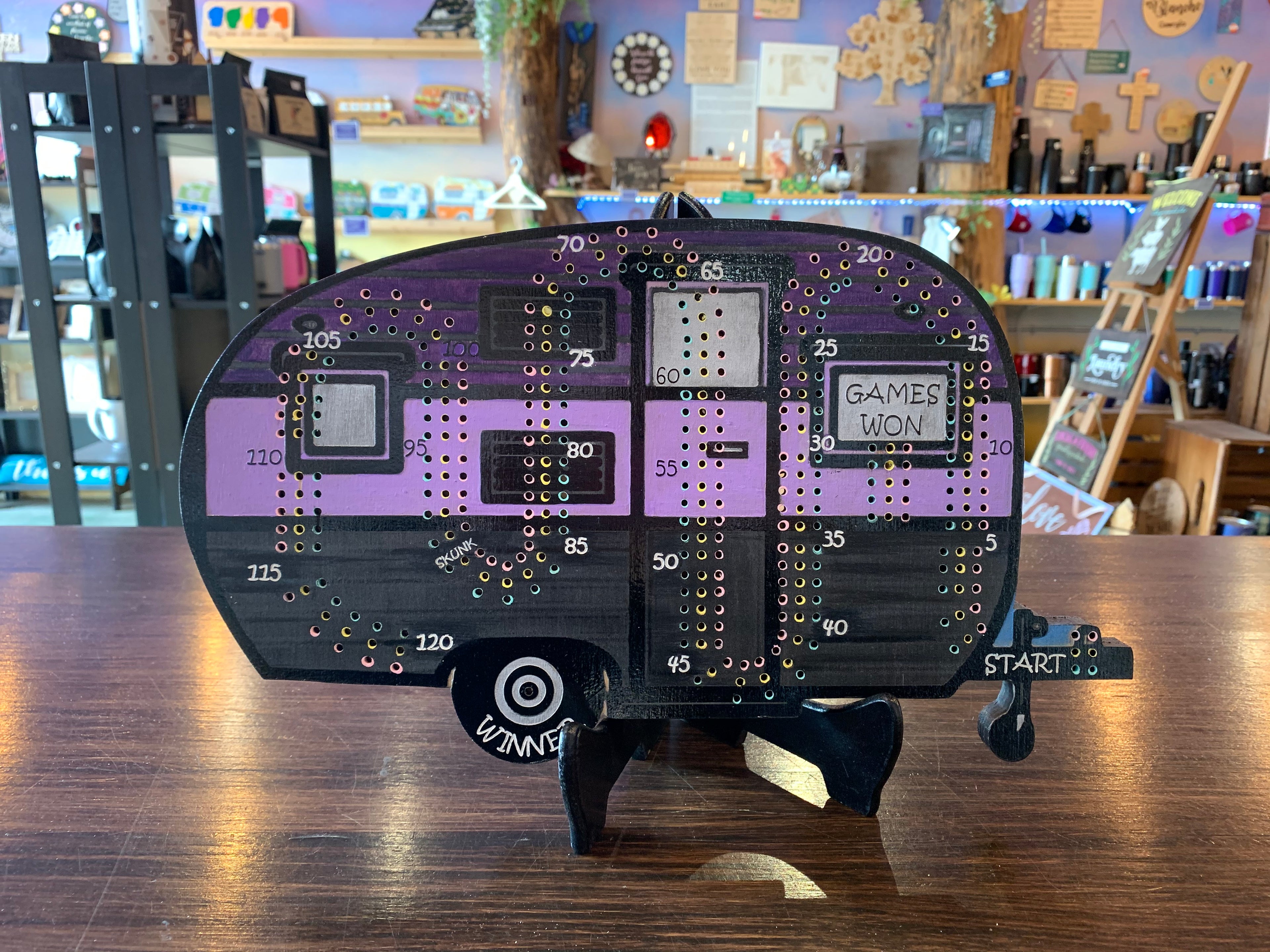 Crib board game component with purple and black design on a wooden surface