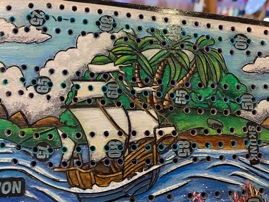 Wooden cribbage board with a ship and palm tree design