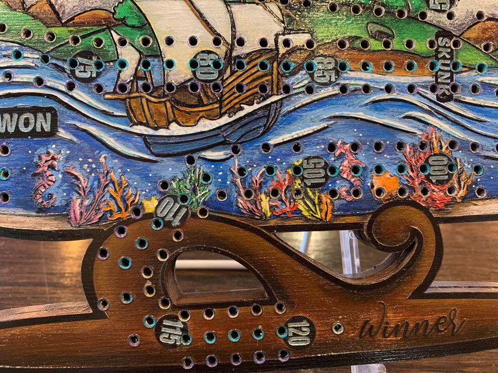 Decorative ship in a bottle cribbage board with a scenic design.