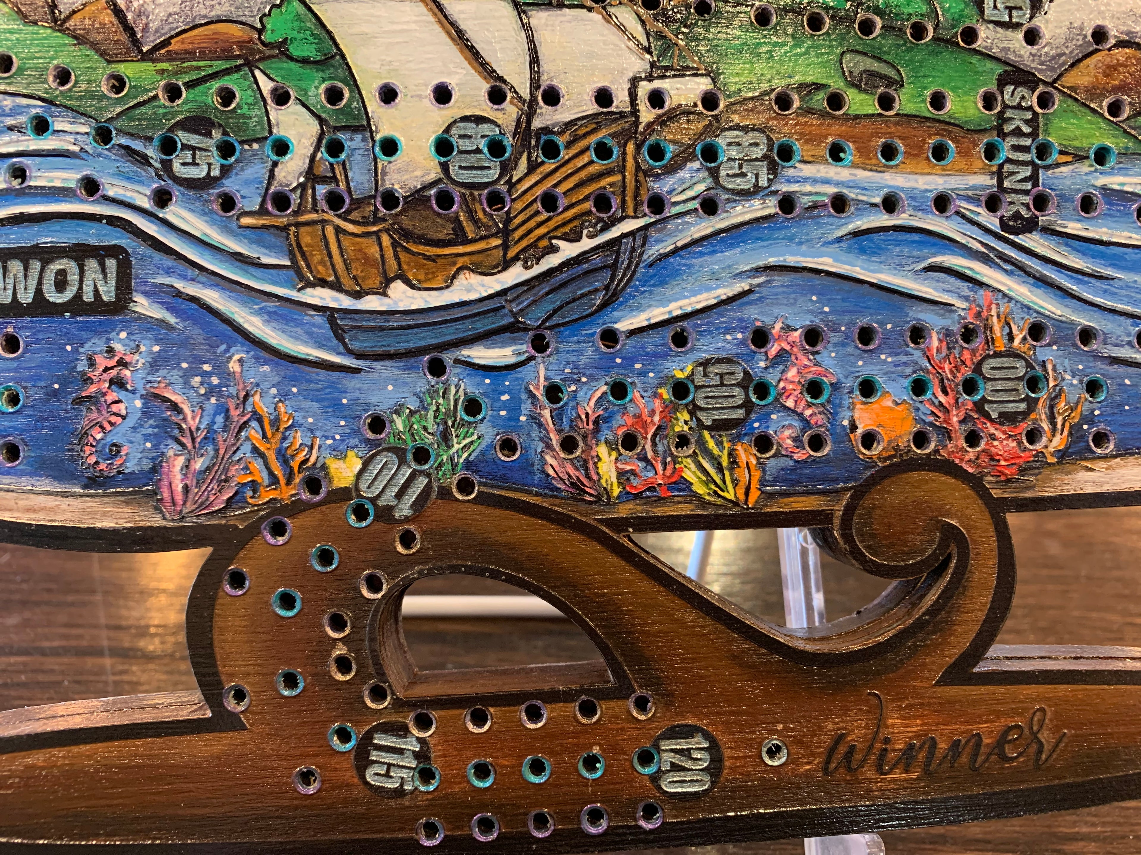 Decorative ship in a bottle cribbage board with a scenic design.