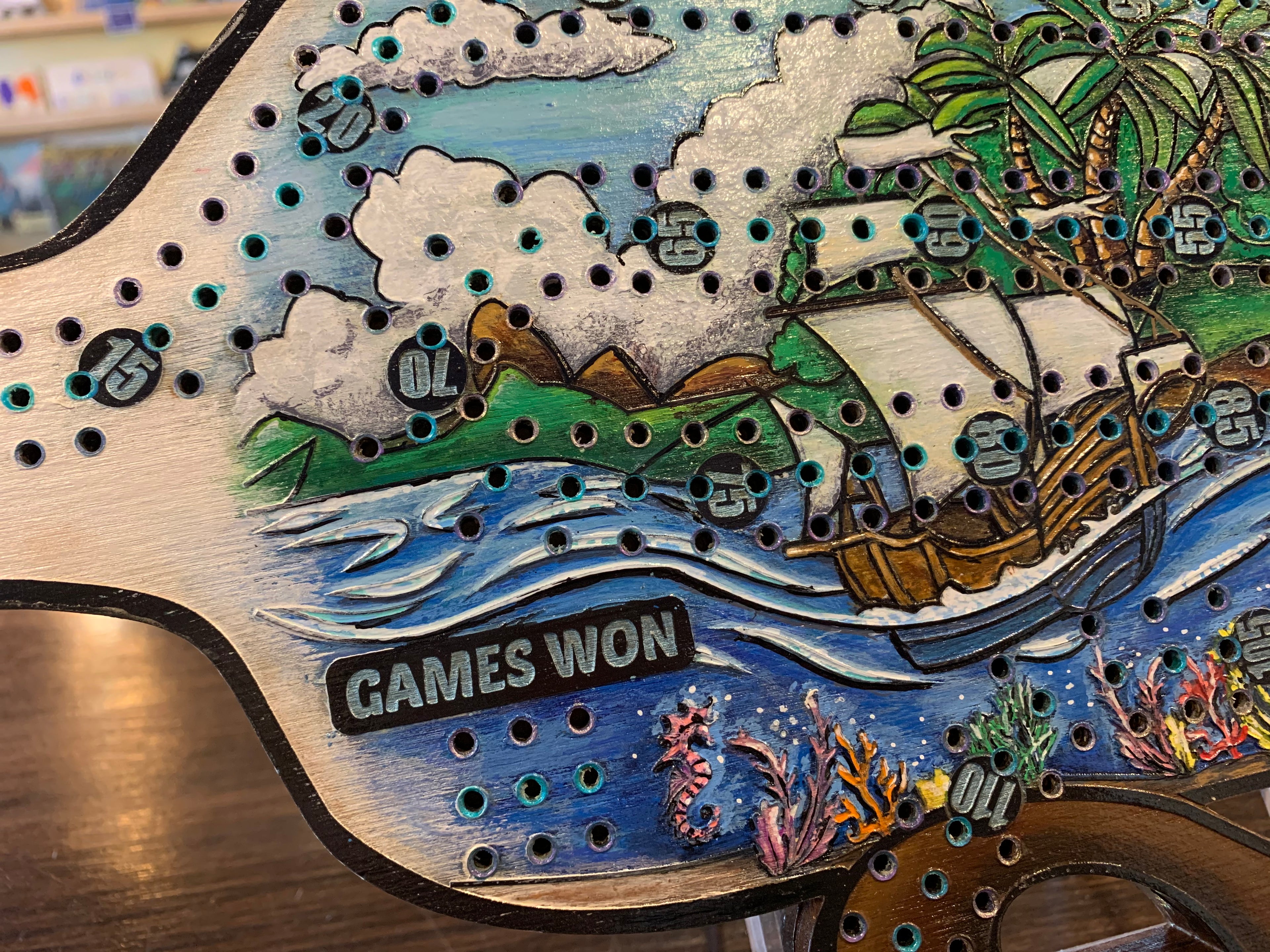 Wooden scoreboard with ship and landscape design, showing 'Games Won' text.