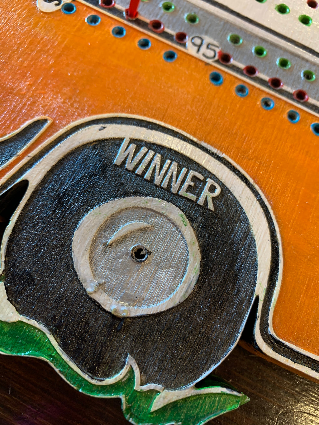 Close-up of a wooden cribbage game with 'Winner' text.